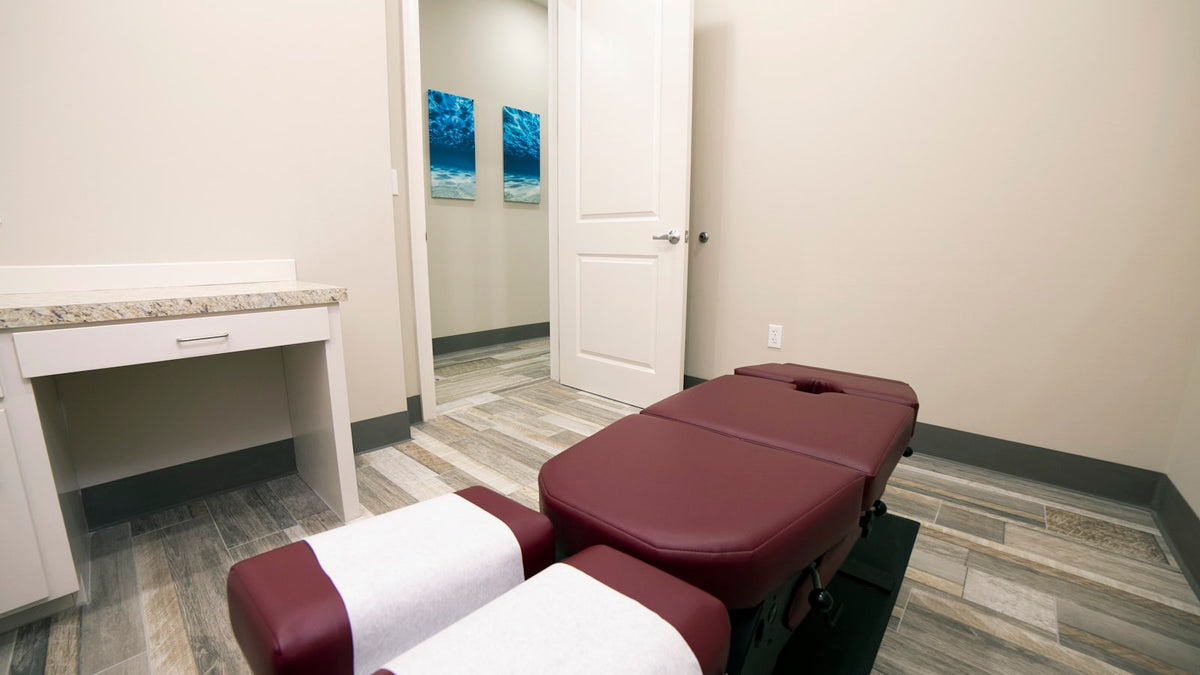 Chiropractic treatment table set up in a clinic treatment room
